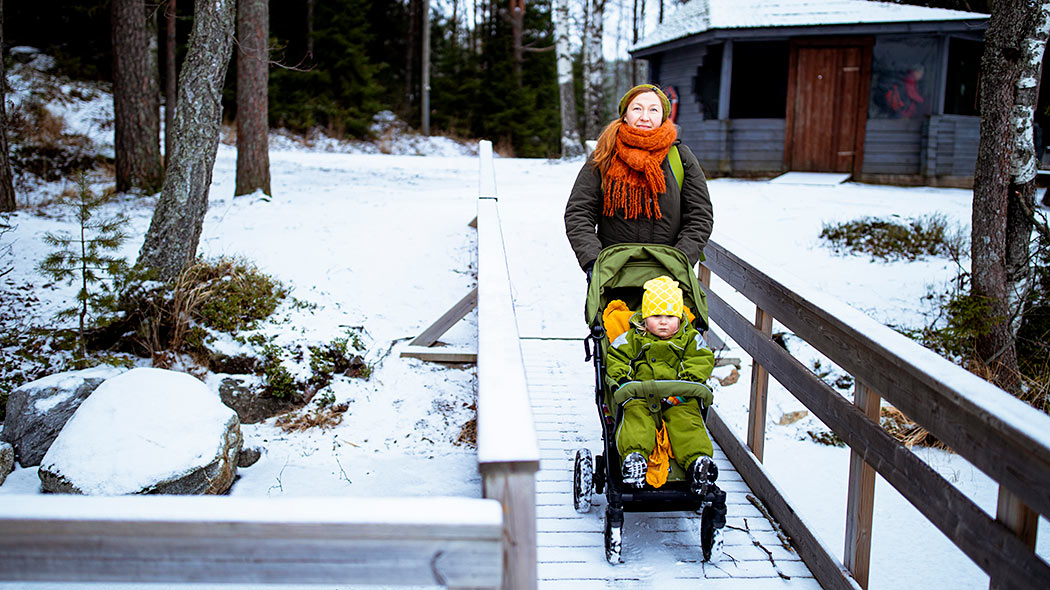 A snowy barrier-free pier where a mother walks with a stroller.