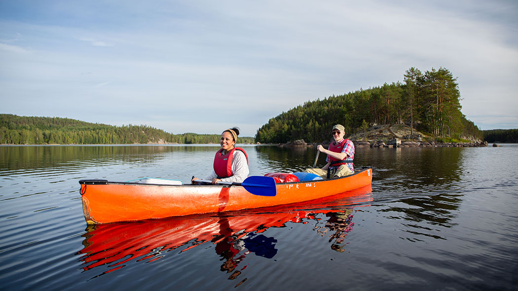 Two happy paddlers on a calm lake.