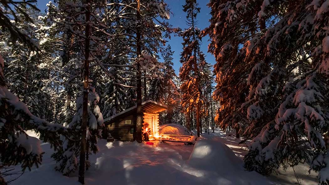 A lean-to shelter and a place to make a fire in the forest on a winter evening.