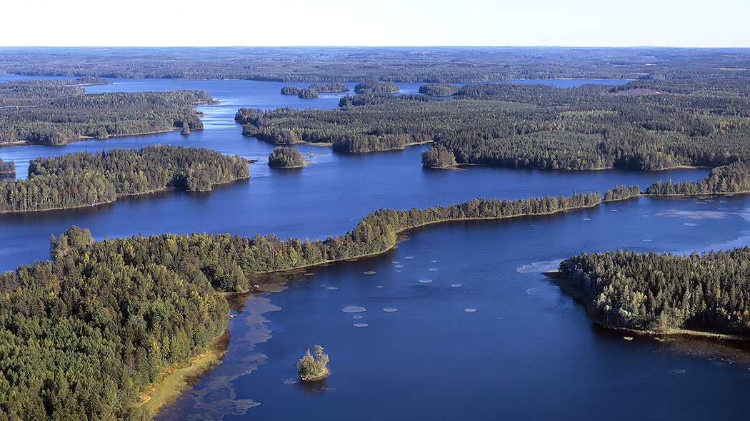 Aerial view showing lake and wooded islands in summer.