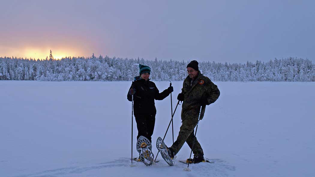 Lake landscape in winter. Two persons with snow shoes.