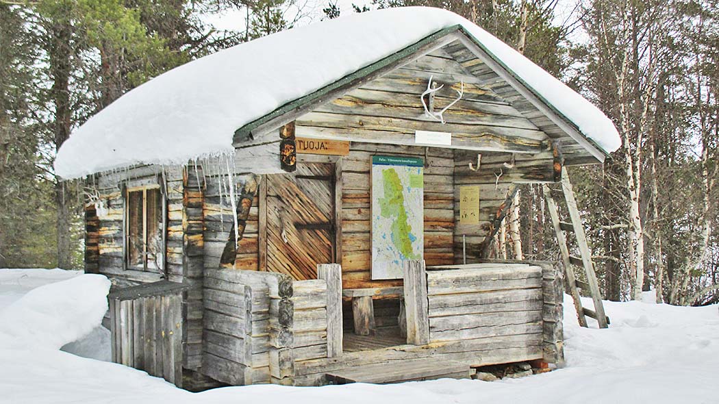 A small hut in snowy scenery.